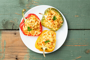 Baked stuffed pepper ( paprika ) with rice , carrot and meat . Top view on rustic background