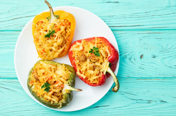Baked stuffed pepper ( paprika ) with rice , carrot and meat . Top view on rustic background