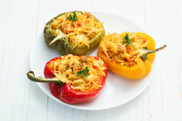 Baked stuffed pepper ( paprika ) with rice , carrot and meat . Top view on rustic background