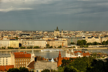 Obraz premium Budapest Hungary. View of the capital in Europe. Cruises ship passes on the Danube River. The imposing Parliament in the background. The bridges with cars, trams and bicycles. Concept photo
