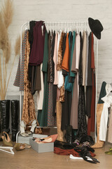 Untidy cluttered woman wardrobe with stylish clothes and accessories. Messy clothes thrown on a...