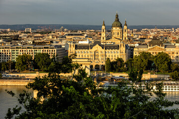 Obraz premium Budapest Hungary. View of the capital in Europe. Cruises ship passes on the Danube River. The imposing Parliament in the background. The bridges with cars, trams and bicycles. Concept photo