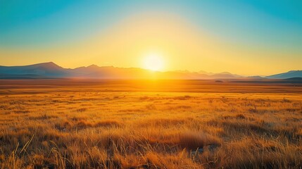 Obraz premium Distant Sunrise: Vivid Yellow Scenery with Mountains in the Background