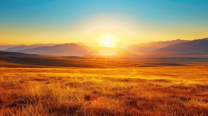 Fototapeta premium Distant Sunrise. Vivid Yellow Sunrise Over Dry Grassy Plains with Mountains in the Distance