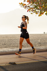 Woman running on the shore of Balne&aacute;rio Cambori&uacute; beach