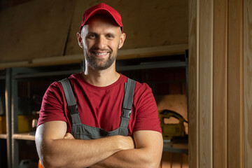 A carpenter stands confidently in a well-organized workshop, showcasing his skills and passion for craftsmanship. The warm, inviting atmosphere highlights the tools and materials.