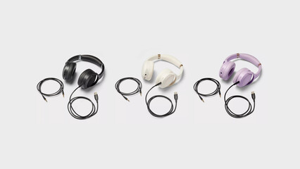 Black, Cream and Violet headphones with cables on copy-space background.