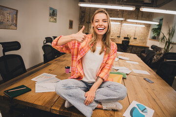 Full size photo of young corporate woman eye wink thumb up loft interior business center office indoors