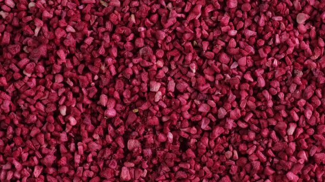 Crunchy pieces of Freeze dried raspberries, close-up. Dehydrated raspberry berries. Delicious fruit topping for porridge, cereal, yogurt and desserts. 4K video, clockwise rotating.