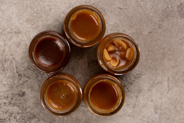 Homemade caramel with different flavors in glass jars