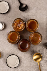 Homemade caramel with different flavors in glass jars