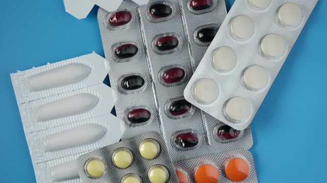 Set Rectal suppositories and Pills for treatment of erectile dysfunction, frequent urination and prostate adenoma. Blue background, Rotation motion.