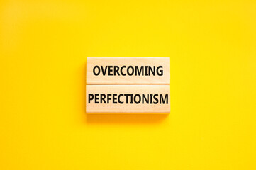 Overcoming perfectionism symbol. Concept words Overcoming perfectionism on beautiful wooden block. Beautiful yellow paper background. Business Overcoming perfectionism concept. Copy space.