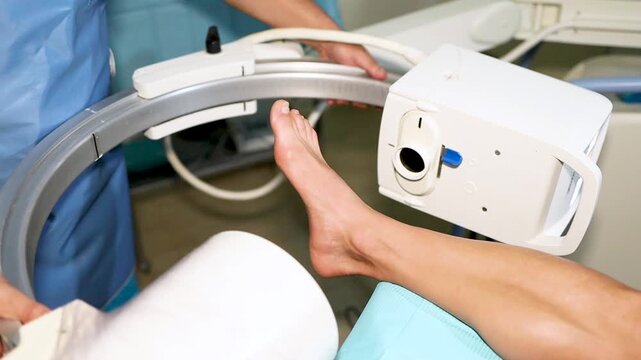 Video of an unrecognizable podiatrist performing a treatment on an athlete's feet.The podiatrist performs fluoroscopy to see the inside of the foot in real time.