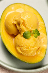 Balls of natural mango ice cream on a slice of ripe mango