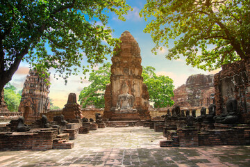 Naklejka premium Ruins of Buddha statues and pagoda in Wat Mahathat, the old Thai temple inside Ayutthaya historical park, Thailand