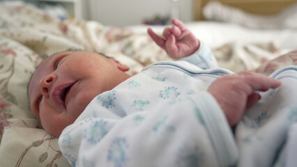 Newborn baby holding an adult's finger with both hands, bond and connection between parent and child, emphasizing the tenderness and care in the early stages of life