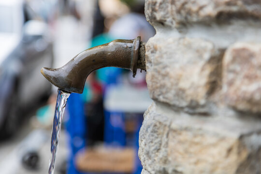 A metal faucet from which water flows in the city of Panagia - Greece