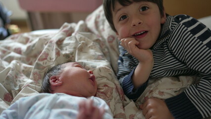 Older brother gazing affectionately at newborn baby, touching gently, bonding moment, indoor...