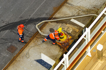 The process of mooring a large ship at the harbor pier, pulling the rope ashore