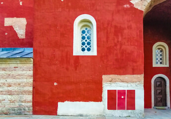 Stone windows on the red facade of the Zica monastery, Serbia