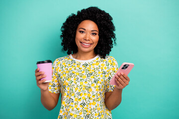 Photo of adorable lovely girl wear print t-shirt chatting modern gadget enjoying beverage isolated turquoise color background