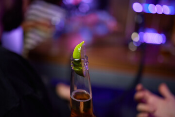 Enjoying a Refreshing Beer with a Lime Slice Placed on Top for Extra Flavor and Zest