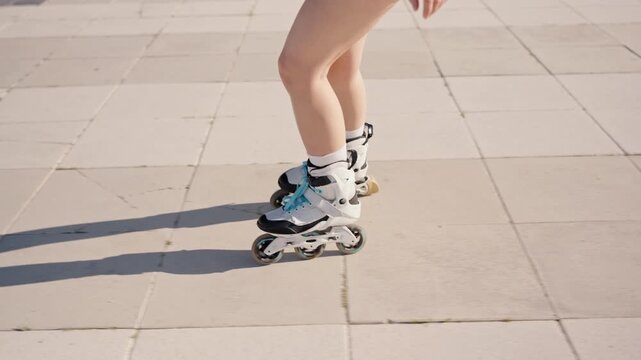 A close-up view of a person's legs rollerblading on a paved surface, showcasing movement and outdoor activity.