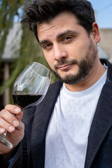 Hombre apuesto degustando una copa de vino	