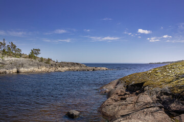 A body of water with a rocky shoreline and a clear blue sky