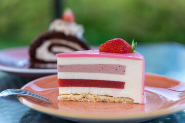 A slice of pink cake with a strawberry on top