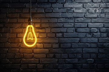 A light bulb is lit up against a brick wall. The light is shining on the wall, creating a warm and inviting atmosphere. The brick wall adds a sense of texture and depth to the scene