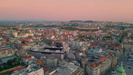 Obraz premium Aerial view city sunrise with red roofs architecture. Peaceful town in evening