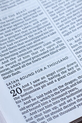 Satan bound for thousand years, biblical verses in open holy bible book. Close-up. Revelation...