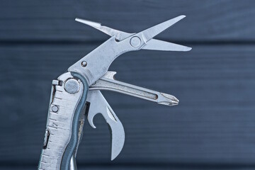 part of gray metal multitool on a black background