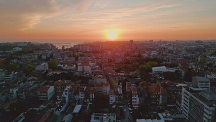 Fototapeta premium Aerial sunset illuminating cityscape in Portugal. Urban landscape at vibrant sky