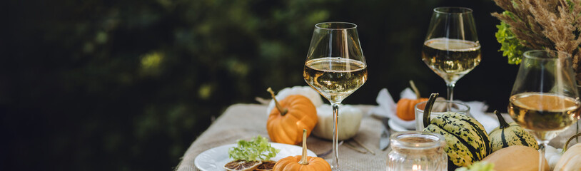 Simple craft elements, pumpkins as decoration, candles. Lunch outdoors in the garden. Cozy dinner table decor for an autumn event, countryside party, thanksgiving dinner or wedding banner