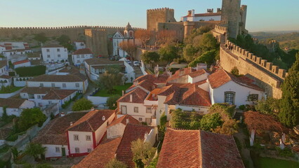 Aerial old historical city rooftops and medieval walls at evening. Stone castle