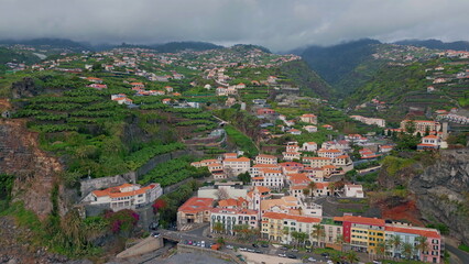 Fototapeta premium Aerial view coastal village with red roofs. Beautiful Madeira travel destination