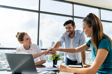 Group of skilled businesspeople putting hands together at modern office.Happy smart business team...
