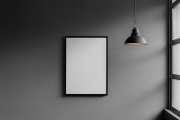 A minimalist black frame hanging on a dark gray wall next to a modern lamp, offering copy space for artwork or design.