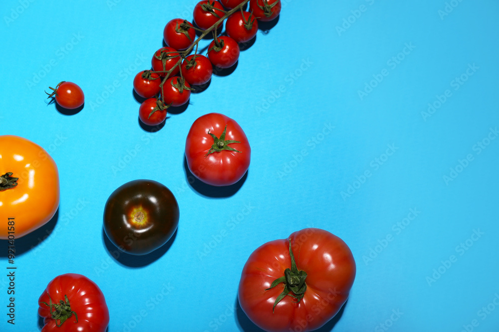 Poster different fresh tomatoes on blue background