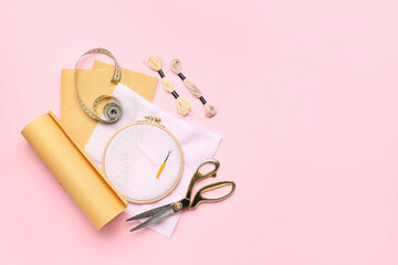 Embroidery hoop with canvases, mouline threads and measuring tape on pink background © Pixel-Shot