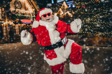 Portrait of astonished excited crazy santa raise fists triumph rejoice newyear evening city center...