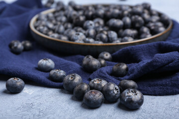 Plate with sweet fresh blueberries on blue background