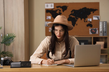 Female spy writing on notebook in office