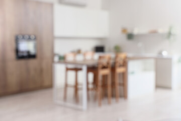 Interior of modern stylish kitchen with dining table. Blurred view