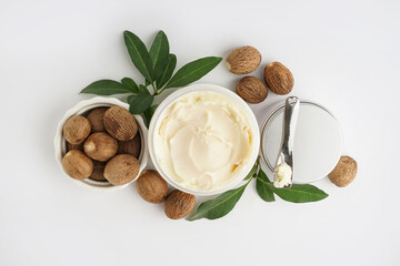 Jars with shea butter and cosmetic cream on white background