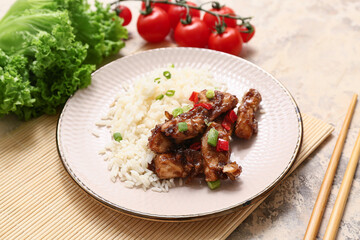 Tasty sweet and sour chicken with rice in plate, vegetables and chopsticks on beige grunge background, closeup