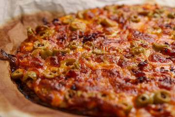 Freshly made pizza with tuna, cheese, tomato and olives